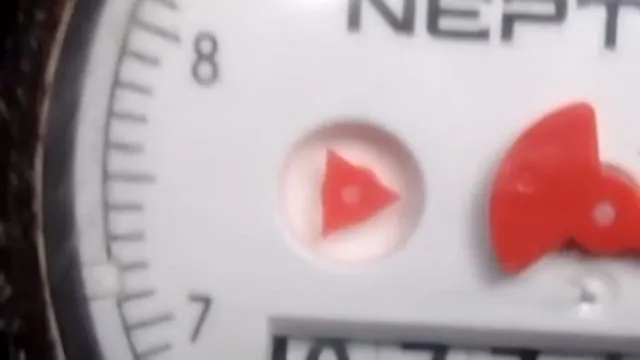 A close view of a water meter dial with a red flow indicator beside the numbers